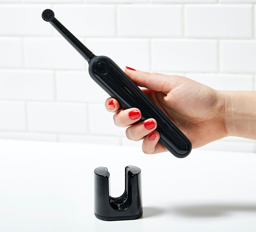 Image d'une main tenant une brosse à dents électrique